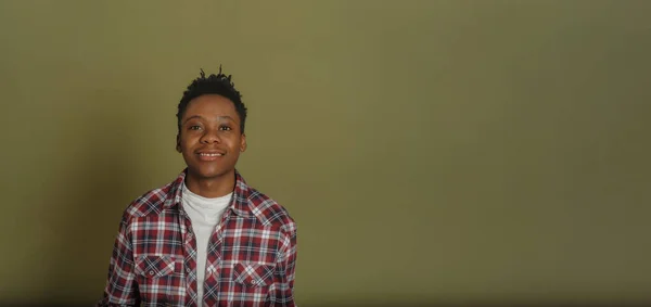 Portrait of young african american man in plaid shirt on green background — Stock Photo, Image