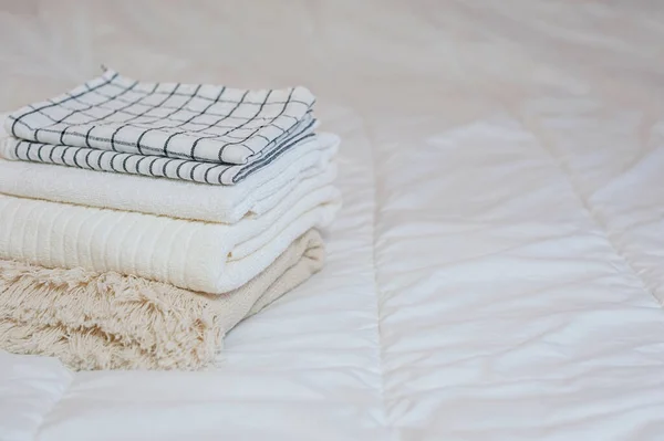 Домашний текстиль. Пачка полотенец лежит на белой кровати. — стоковое фото