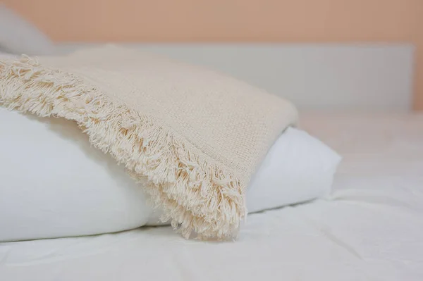 Stapel witte kussens en dekens ligt op het bed op een wit laken bovenop, bedekt met een deken Stockafbeelding