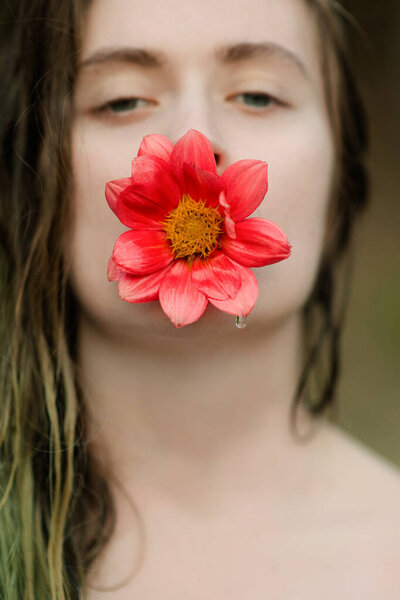 girl holding a red flower in her mouth. Concept photo