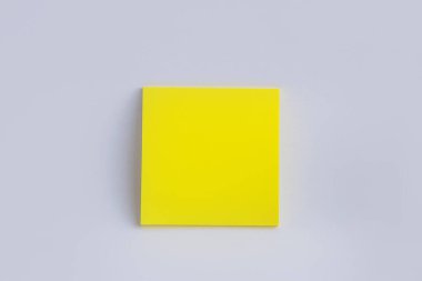 Beyaz arka planda sarı yapışkan bir not. Renkli kağıt not. Okula geri dönüş konsepti