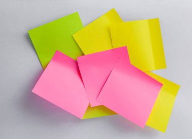 Beyaz arka planda sarı, yeşil, pembe yapışkan bir not. Renkli kağıt not. Okula geri dönüş konsepti