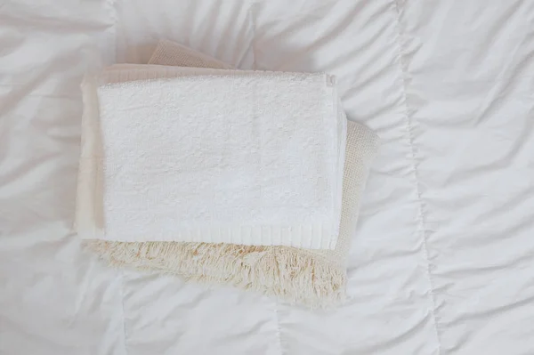 Домашний текстиль Flatlay. Пачка полотенец лежит на белой кровати. — стоковое фото