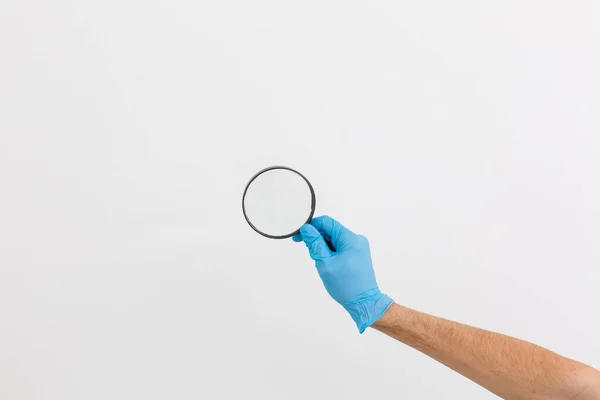 Gesto Mão Uma Luva Médica Azul Com Uma Lupa Isolada — Fotografia de Stock