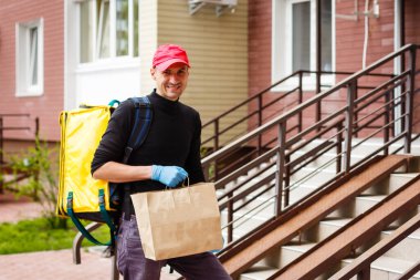 Teslimat, posta ve insanların konsepti mutlu bir adamın tek kullanımlık kağıt torbalarla müşteriye yemek götürmesi.