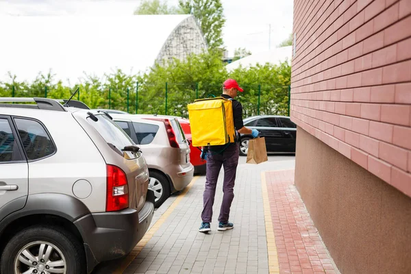 delivery, mail and people concept happy man delivering food in disposable paper bag to customer home