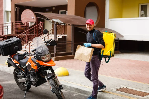 delivery, mail and people concept happy man delivering food in disposable paper bag to customer home