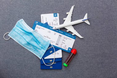 Pasaportlu uçuş biletleri, uçak modeli ve gri arka plandaki harita..