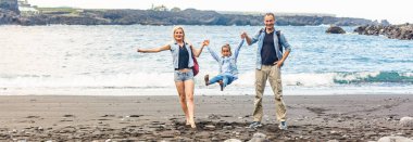 Mutlu aile şafak vakti sahilde duruyor.