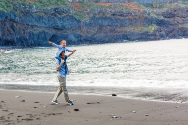 Mutlu aile şafak vakti sahilde duruyor.