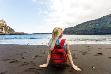 Güzel, orta yaşlı sağlıklı bir kadının, güneşli bir tatil gezisinde kayalık bir plajı ziyaret edişinin portresi, açık havada gülümsüyor. Olgun kadın neşeli ifadesi, aktif eğlence eğlence eğlence yaşam tarzı.