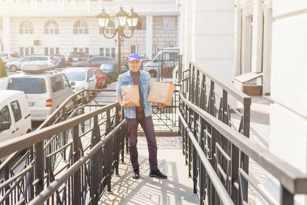 delivery, mail and people concept - man delivering coffee and food in disposable paper bag to customer home