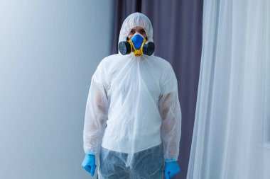 Koruyucu giysili adam, maske ve solunum cihazı..