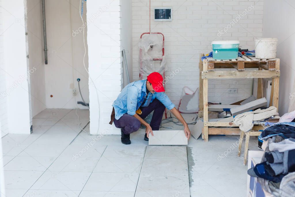 The master puts ceramic tiles on the floor