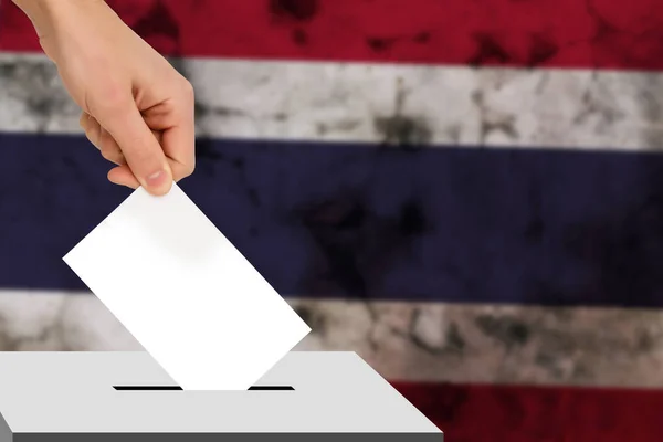 hand drops the ballot election against the background of the flag, concept of state elections, referendum