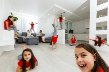 Kızgın genç ebeveynler mutfakta kanepede oturur gürültülü küçük kız koşar, endişeli anne ve baba evdeki kanepede dinlenir yaramaz çocuk yüzünden yorgun düşerler.