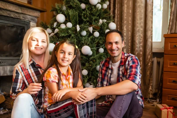 Family in an old wooden house. Beautiful christmas decorations. The festive mood. Christmas holidays.