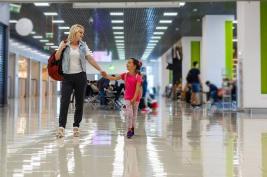 Mutlu anne ve kız uçağa binmeden önce havaalanında oyun oynuyorlar.