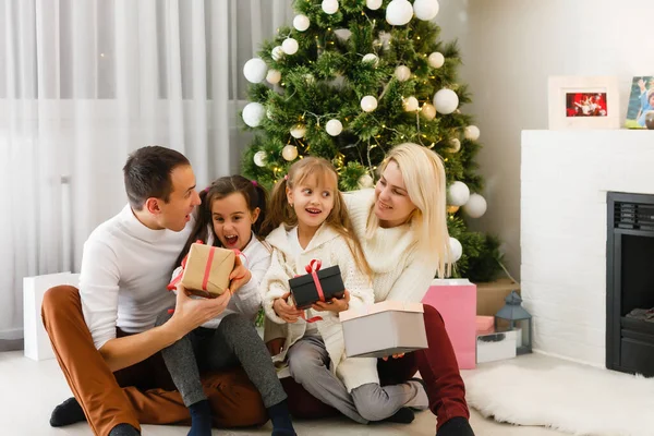 happy family father mother and children sitting by fireplace on Christmas Eve