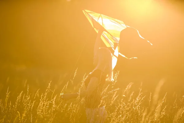 Ευτυχισμένη Νεαρή Γυναίκα Τρέχει Έναν Χαρταετό Ένα Ξέφωτο Στο Ηλιοβασίλεμα — Φωτογραφία Αρχείου