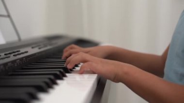 Piyano klavyesine gülümseyen küçük kız