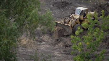 Kazı makinesi yol çalışması yapıyor. Bir kovayla toprağı kazıyor. Yol ekipmanı operasyonu