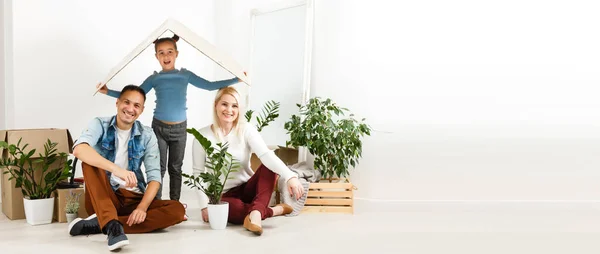 Happy family with cardboard boxes in new house at moving day.