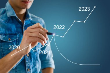 Man's hand pointing graph of success in 2022 year. Growing business concept. High quality photo clipart