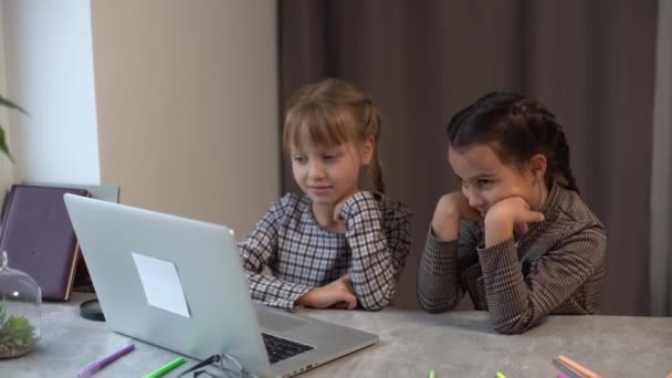 家庭での教育の概念 ノートパソコンで宿題をする勉強をする2人のかわいい遊び心のある女の子 — ストック動画