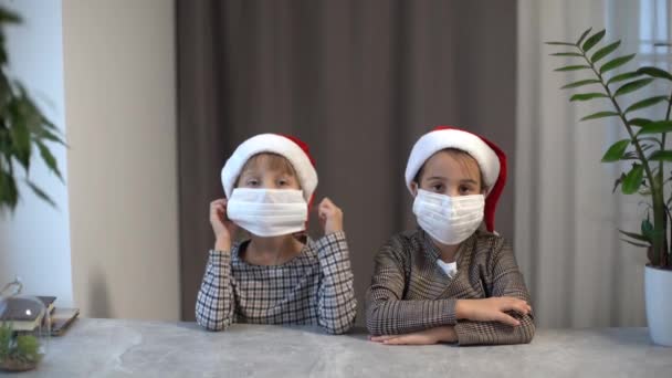 Dua Gadis Kecil Bertopi Santa Melepas Topeng Medis — Stok Video
