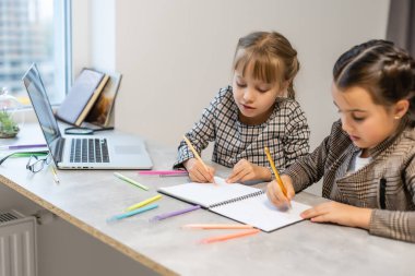 İki küçük kız okul ödevlerini yapıyor.