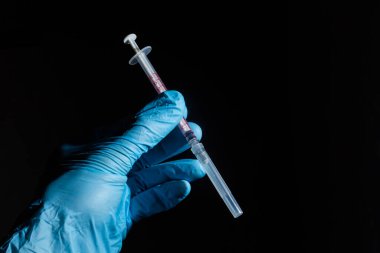 Doktor elinde COVID 19 Coronavirus aşısı tutuyor, örnek tüpte kan örneği, aşı ve şırınga enfeksiyonu COVID-19 'dan korunma, aşılama ve tedavi için kullanılıyor.