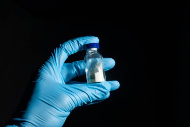 Tıbbi eldiven verin. Coronavirus Covid-19 aşı şişesi, yakın çekim detayları.