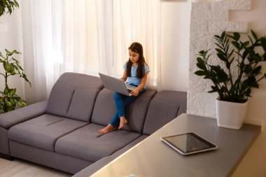 Küçük kız bilgisayarla çalışıyor.