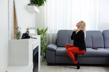 Genç bir kadın evde dua ediyor.