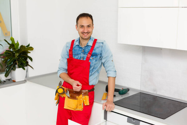 kitchen installation. Worker assembling furniture