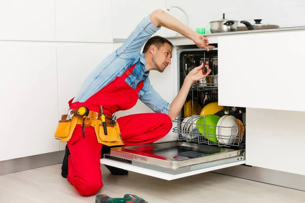 Técnico Masculino Sentado Perto Máquina Lavar Louça Cozinha — Fotografia de Stock