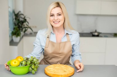 Gülümseyen kadın elmalı turta yapıyor..