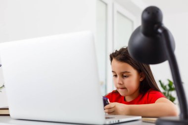 Liseli kız evde dizüstü bilgisayar kullanarak ders çalışıyor. Ev okulu, çevrimiçi eğitim, ev eğitimi, karantina konsepti - Görüntü