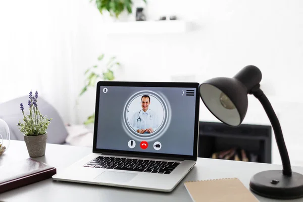 video chat with doctor on laptop at home