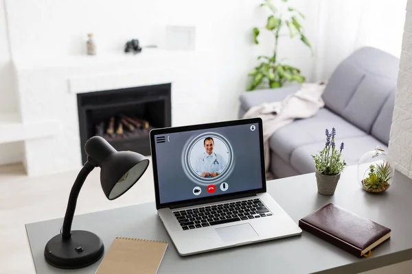 video chat with doctor on laptop at home