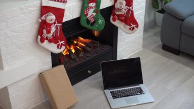 Yılbaşı geçmişi olan bir not defteri. Yeşil laptop ekranı. Tatil ve iş zamanı. Şöminenin yanındaki ev işyeri.