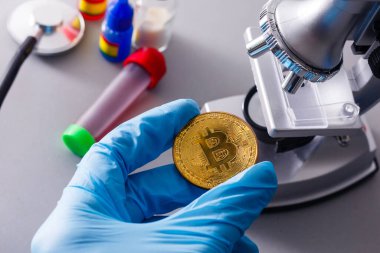 Para şifreli para birimi bitcoin, döviz kurunun yükselişi veya düşüşü nedeniyle altın takas piramidinin mikroskop fon temasında yatar.