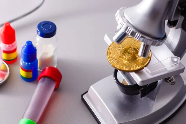 硬币加密货币比特币位于由于汇率变动而形成的货币兑换黄金金字塔的显微镜背景主题上 — 图库照片