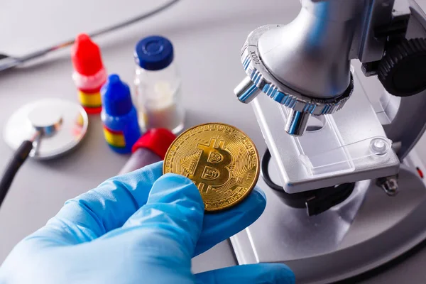 Coin crypto currency bitcoin lies on the microscope background theme of the gold exchange pyramid for money due to the rise or fall of the exchange rate.
