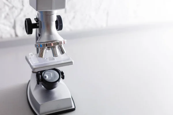 Microscópio Está Uma Mesa Sobre Fundo Branco — Fotografia de Stock