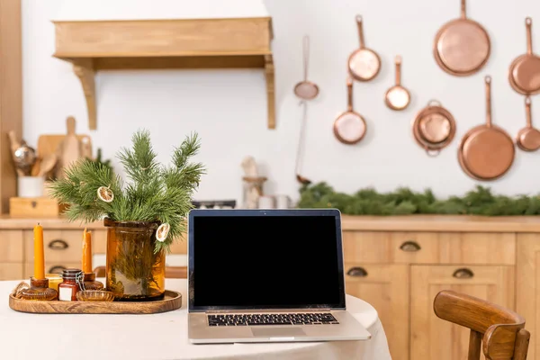 laptop stands on the table in christmas interior. Internet commerce on winter holidays concept