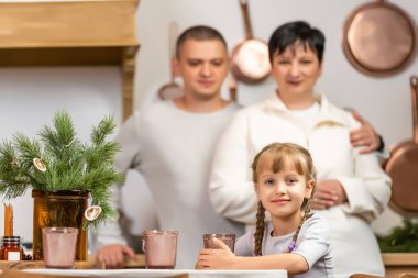 Tatiller, aile ve kutlama konsepti. Mutlu anne, baba ve küçük kız evde Noel yemeği yiyor.