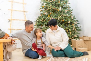 Genç mutlu aile Noel ve Noel kutlamaları için hazırlanıyor.