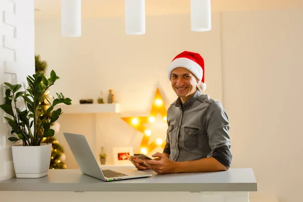 クリスマスのために自宅でクレジットカードでオンラインショッピング若い男 クリスマスショッピングのコンセプト — ストック写真